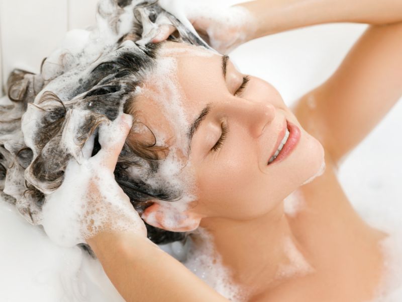 A happy woman washing her hair