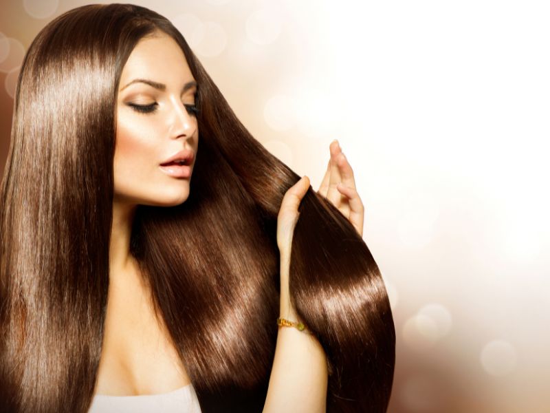 A woman holding her natural straight hair